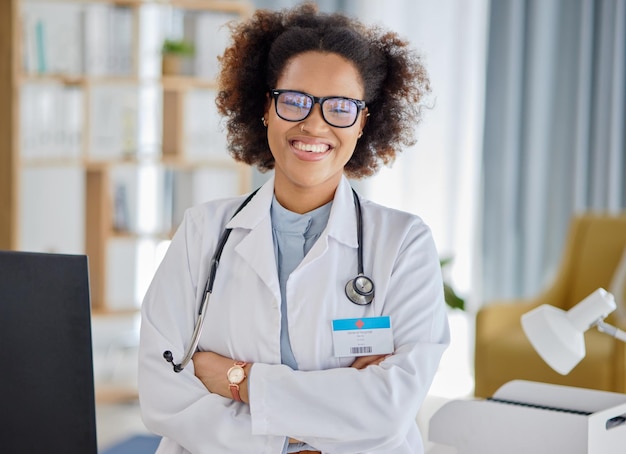 Portret van zwarte vrouw en arts met gekruiste armen voor consultatie ziekenhuisondersteuning en hulp Gelukkig zelfverzekerde vrouwelijke therapeut klaar voor professioneel advies en vertrouwen in de gezondheidszorgkliniek
