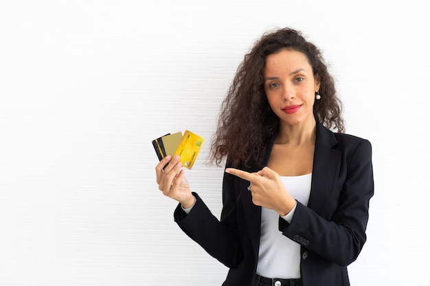Portret vrolijk opgewonden Latijns zakenvrouw krullend haar model creditcard bij de hand te houden.
