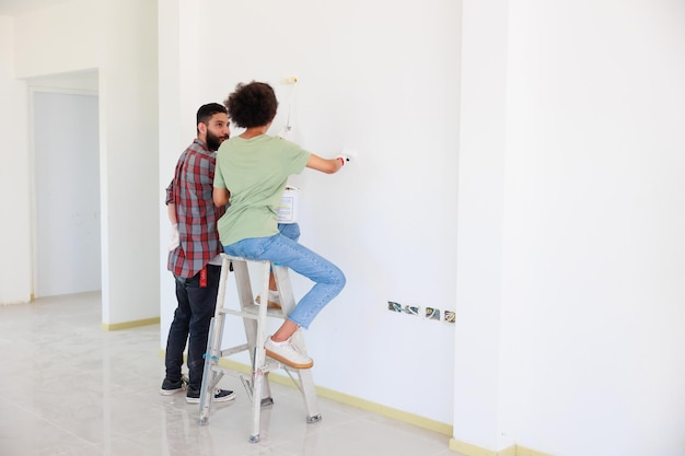 Portret Vrolijke paar jonge man en zwarte vrouw die lacht tijdens renovatie in nieuw appartement Jonge gelukkige familie huis renoveren en slaapkamer plannen