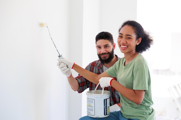 Portret Vrolijke paar jonge man en zwarte vrouw die lacht tijdens renovatie in nieuw appartement