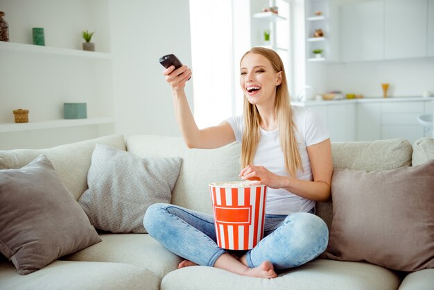 Portret vrouw die thuis popcorn eet