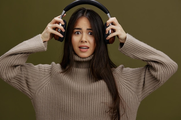 Portret vrouw in koptelefoon die naar muziek luistert emoties Groene achtergrond Hoogwaardige foto