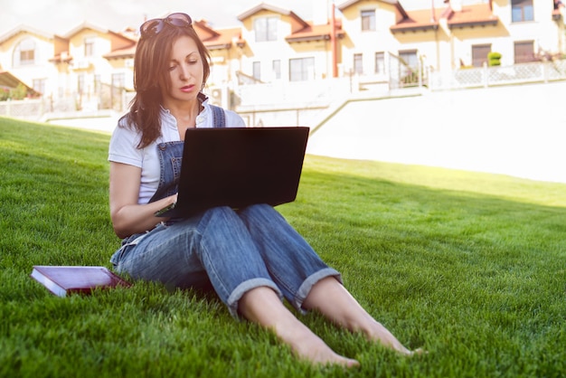 Portret vrouw in park met laptop