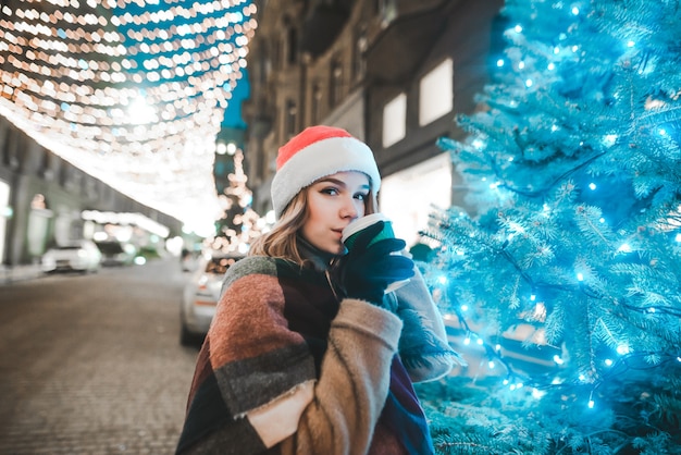 portret vrouw met kerstmuts bedrijf kopje koffie