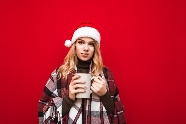 portret vrouw met kerstmuts kopje koffie te houden