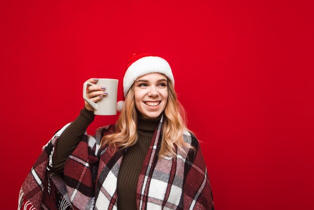 portret vrouw met kerstmuts kopje koffie te houden