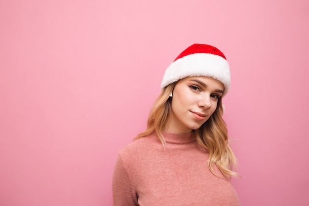 portret vrouw met kerstmuts luisteren naar muziek in draadloze koptelefoon