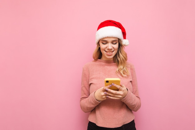 portret vrouw met kerstmuts luisteren naar muziek in draadloze koptelefoon