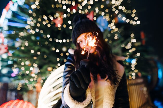 portret vrouw op een kerstmarkt versierd met lantaarns