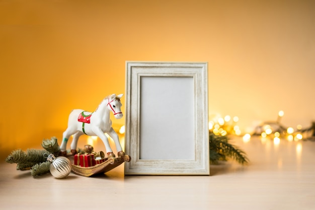 Portret witte fotolijst mockup op tafel met boken lichten en kerstversiering. hoge kwaliteit foto