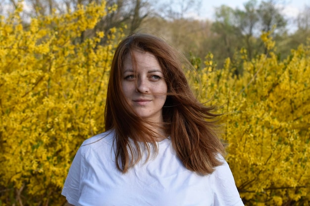 Portret di donna in camicia bianca su sfondo giallo