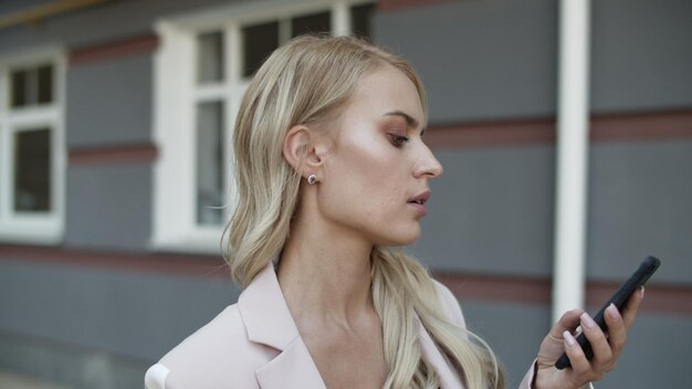 Portret zakenvrouw met behulp van telefoon op straat Vrouw kijken naar mobiele telefoon