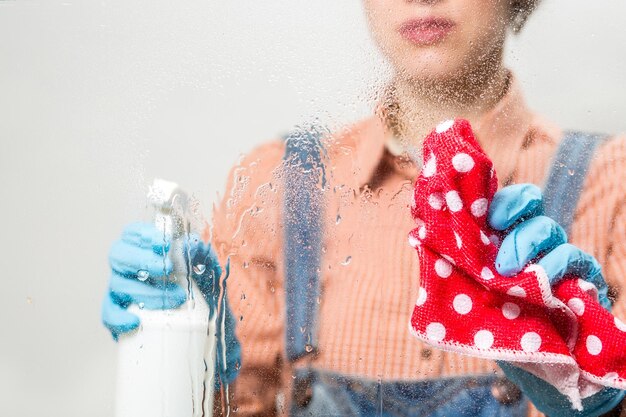 Portret zelfverzekerde vrouw met schoonmaakspullen voor de keuken Huishoudster