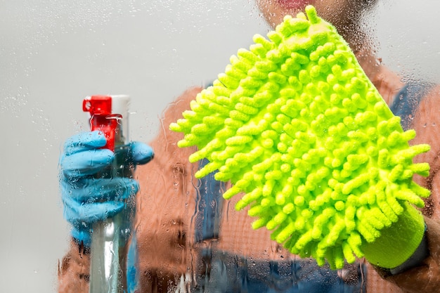 Foto portret zelfverzekerde vrouw met schoonmaakspullen voor de keuken huishoudster