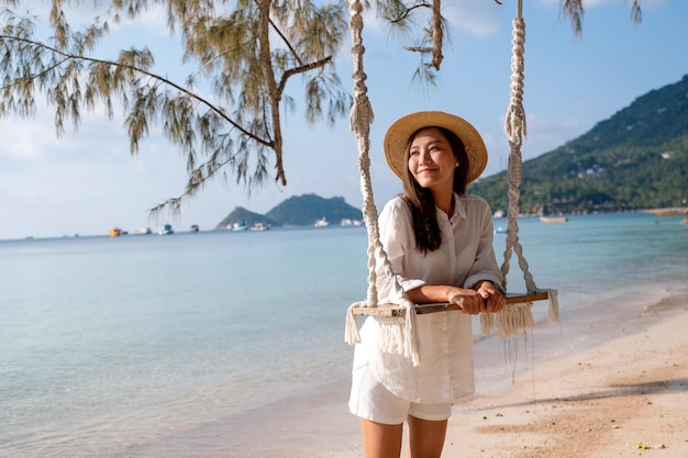 Portretbeeld van een mooie jonge Aziatische vrouw met schommel aan zee