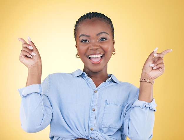 Portretdans en feest met een opgewonden zwarte vrouw op een gele achtergrond in de studio die er gelukkig uitziet Glimlachenergie of verrassing en een jongere die juicht voor succes of bonus met motivatie