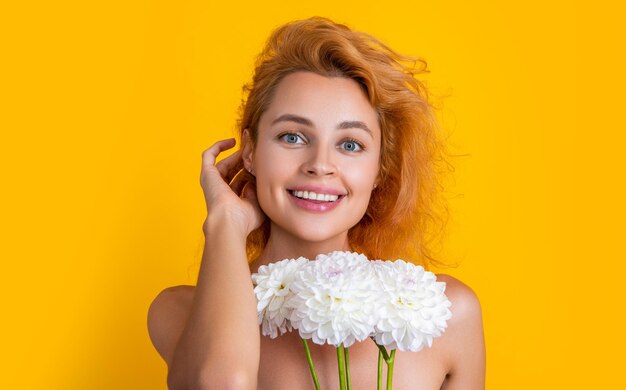 Portretfoto van een vrouw met chrysantenbloemen voor de dag van de vrouw