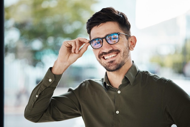 Portretgezicht van de mens en blij met een bril voor gezichtsvermogen en lens op sterkte Jonge mannelijke persoon glimlacht met nieuw frame voor designerbrillen optische mode en beoordeling in oogzorgkliniek