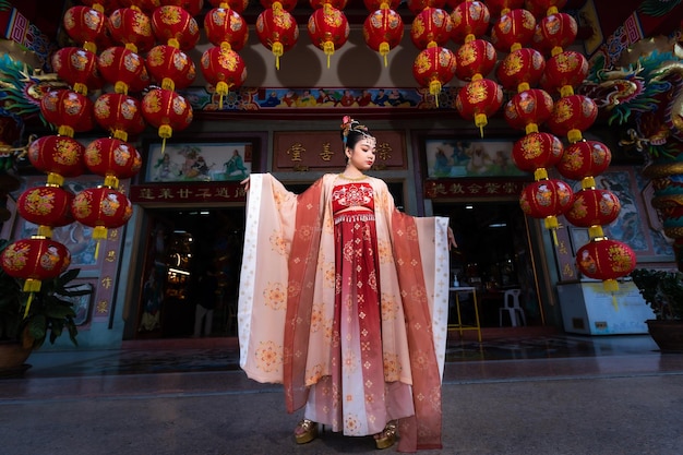 Portretglimlach Schattig klein Aziatisch meisje met Chinese kostuumsdecoratie voor Chinees nieuwjaarsfestival viert de cultuur van China bij Chinees heiligdom Openbare plaatsen in Thailand