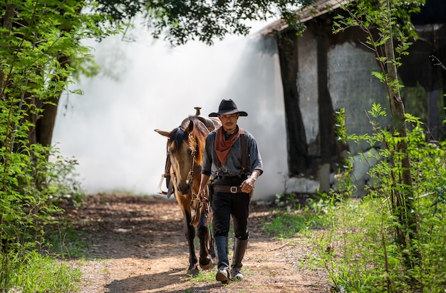 portretmens die met paardboom lopen als cowboy