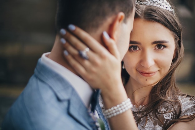 Portretten van mooie sensuele bruidspaar zachtjes knuffelen in Europese stad Stijlvolle bruid en bruidegom zoenen en omhelzen op de achtergrond van de oude kerk Romantisch moment Provence bruiloft