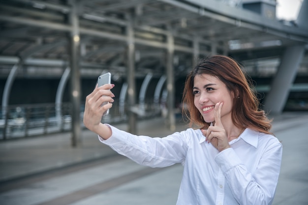 Portretten van vrij mooie Aziatische vrouw die een foto nemen door selfie in stedelijk.