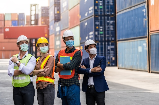 Portrit worker man using a laptop waring surgical mask and safety white head to protect for pollution and virus in workplace during concern about covid pandemic