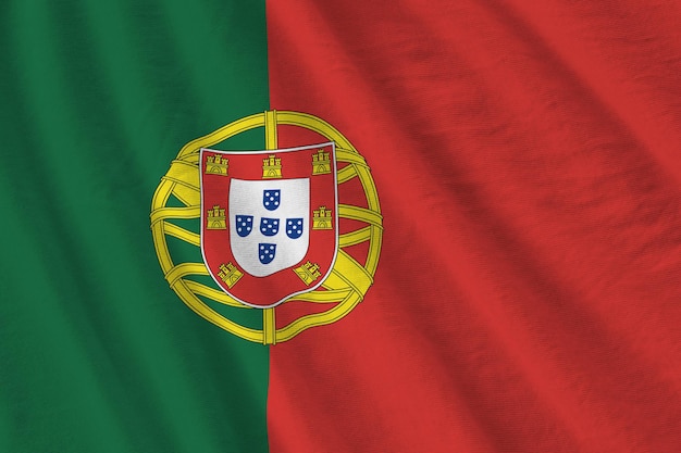 Portugal flag with big folds waving close up under the studio light indoors the official symbols and