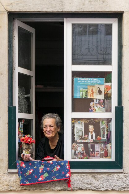 Portugal Lissabon 10052023 Beroemde oudere dame inwoner van Lissabon zit bij het raam met haar kat in een hoed