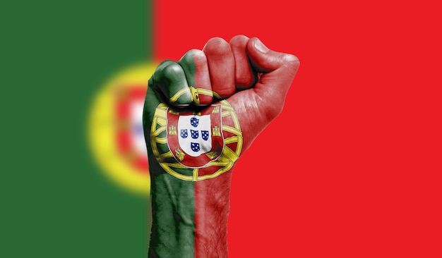 Foto portugal vlag geschilderd op een gebalde vuist kracht protest concept