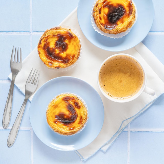 Portugees dessert Pastel de nata met koffie op blauwe tegel