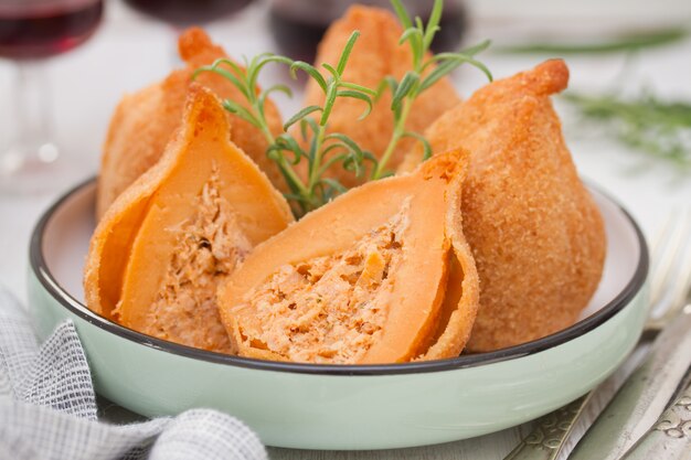 Portugese schotel coxinhas de frango op plaat met rode wijn