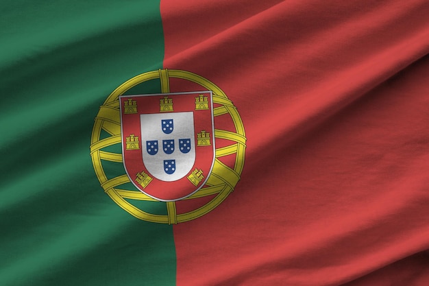 Portugese vlag met grote vouwen die van dichtbij zwaaien onder het studiolicht binnenshuis de officiële symbolen en