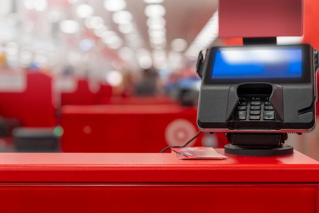 A pos machine at woolworths supermarket\'s selfserve checkout\
area with blur bokeh background