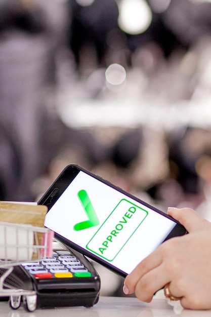 Terminale pos macchina di pagamento con telefono cellulare sullo sfondo del negozio pagamento contactless con tecnologia nfc
