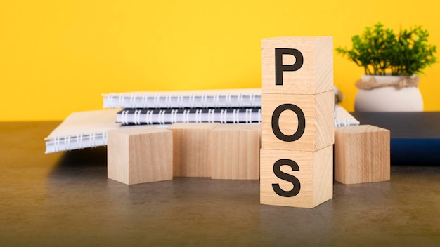 POS text on wood cubes stack yellow background