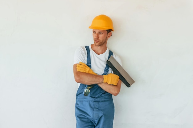 Poseren voor de camera Jonge man aan het werk in uniform bij de bouw overdag