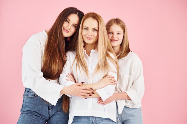 Poseren voor een camera Jonge moeder met haar twee dochters is in de studio