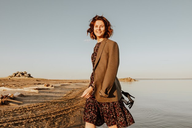 Poserende vrouw in de natuur. Jonge vrouw in stijlvolle kleding