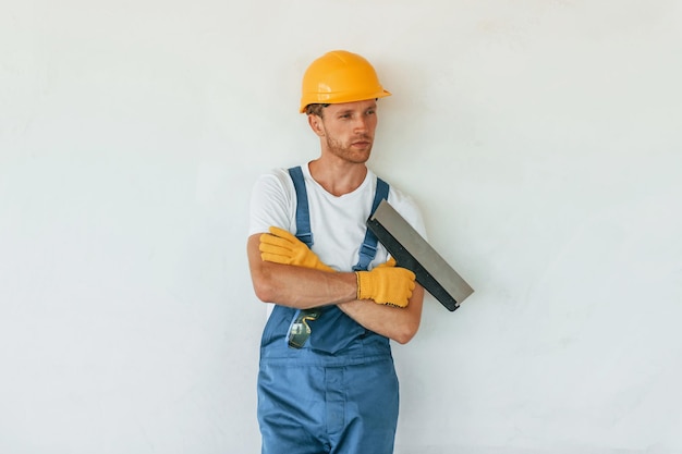 カメラのポーズ昼間建設で制服を着て働く若い男