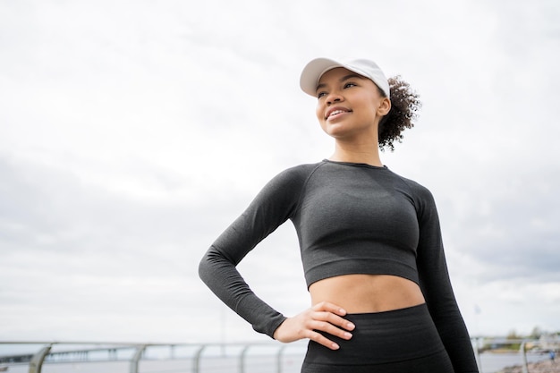 Posing confident athletic woman trains in sportswear