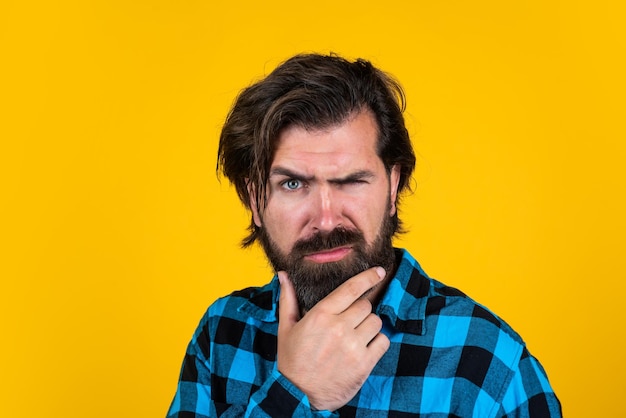 Posing for photo mature guy with moustache on face expressing human emotions serious man in checkered shirt emotional man on yellow background brutal bearded hipster