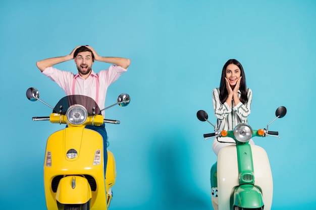 Positief gek energiek twee motorrijders man vrouw aandrijfkracht motoren zien er ongelooflijk uit korting advertenties onder de indruk aanraking handen wangen gezicht schreeuwen geïsoleerd over blauwe kleur muur