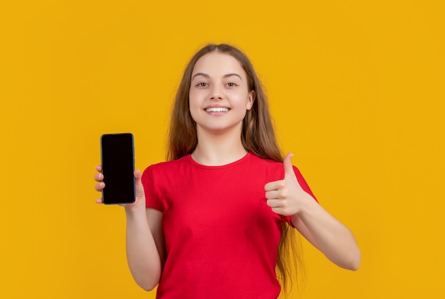 Positief kind met smartphone op gele achtergrond