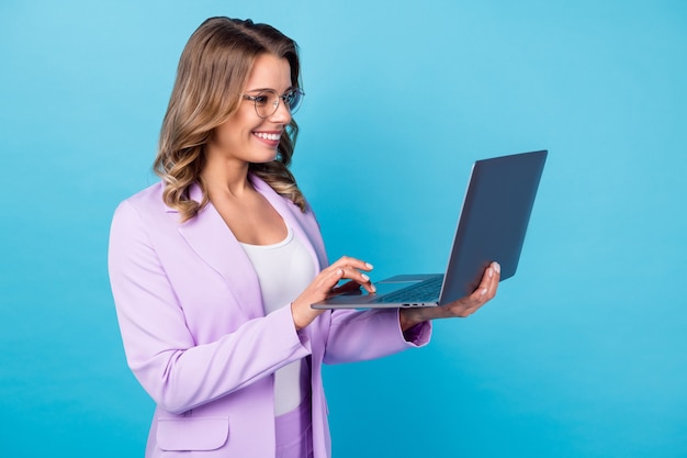 positief meisje werk laptop type e-mail geïsoleerd over blauwe kleur
