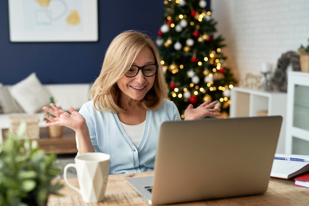 Positief verrast volwassen vrouw tijdens een videoconferentie