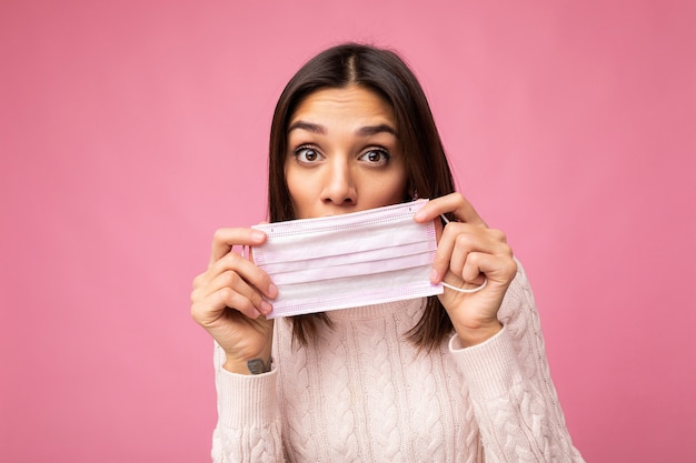 Positief verrast vrouw met een antivirus-beschermingsmasker om anderen te voorkomen