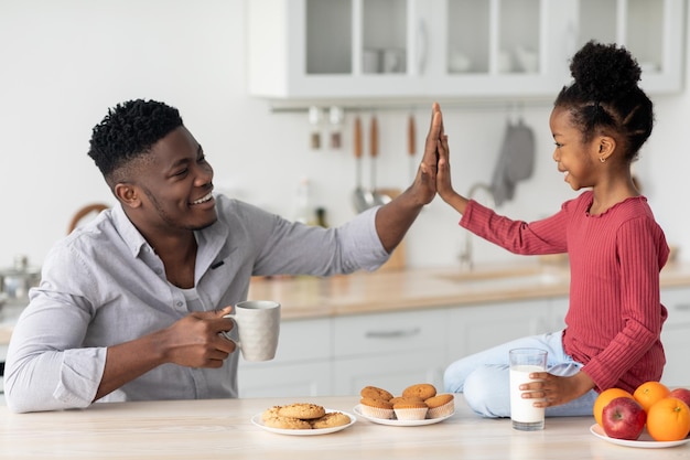 Positieve Afro-Amerikaanse vader en dochter met snack