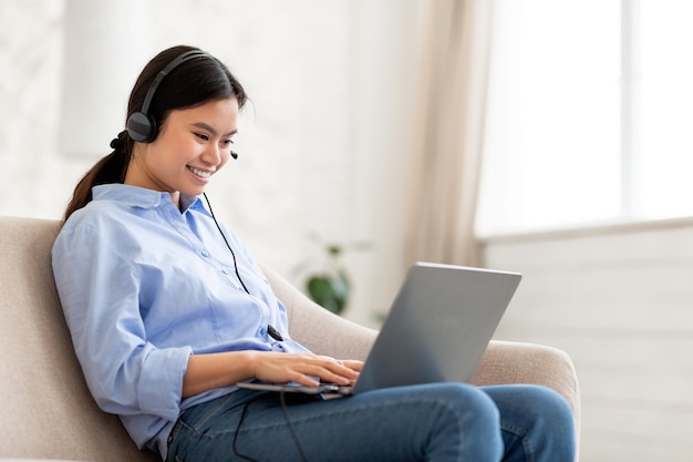 Positieve aziatische vrouw met online sollicitatiegesprek vanuit huis