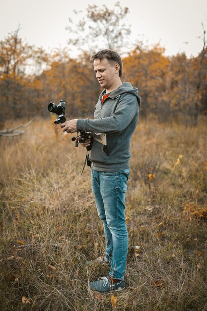 Positieve cameramens die camera op digitale stabilisator voorbereidt voor het fotograferen van foto- en videocontent